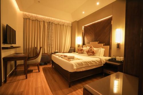 a hotel room with a bed and a desk at raj Regent kurichy in Putuppalli