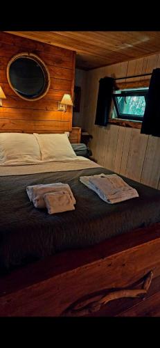 a bedroom with a bed with two towels on it at Les Cabanes du Beau Vallon in Profondeville