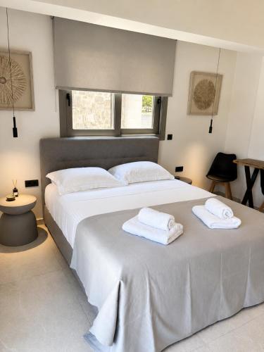 a bedroom with a large white bed with towels on it at Elysian View Lefkakia in Nafplio
