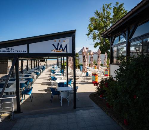 a row of tables and chairs at a restaurant at Complex Vraja Mării Costinești in Costinesti