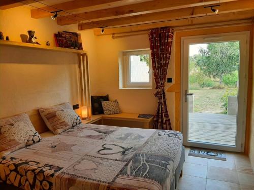 a bedroom with a bed and a sliding glass door at Estefana in Chambilly
