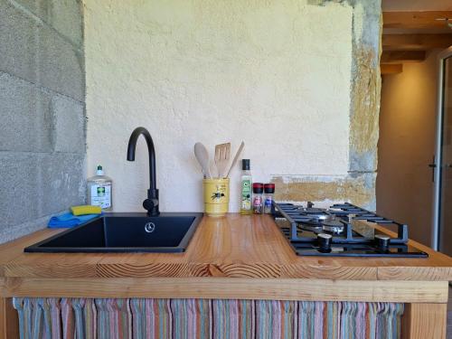 a kitchen counter with a sink and a stove at Estefana in Chambilly