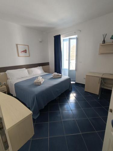 ein Schlafzimmer mit einem Bett, auf dem zwei Handtücher liegen in der Unterkunft Tuareg Hotel in Campomarino