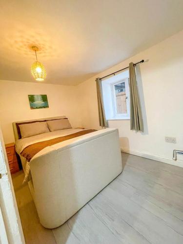 a bedroom with a large bed and a window at Charming 1-Bed on High St in Longwell Green