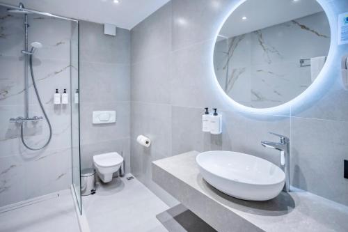 a bathroom with a sink and a glass shower at ELIA MARe Hotel ALL Inclusive - Free Beach Access in Kiten