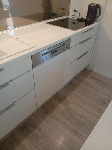 a kitchen with white cabinets and a sink at Apartman DALIAROSE Sarajevo in Sarajevo