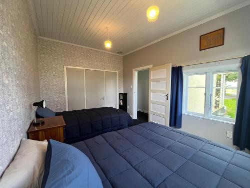 a bedroom with two beds and a window at Destination Cliff Top - Cottage and Homestead in Ohingaiti