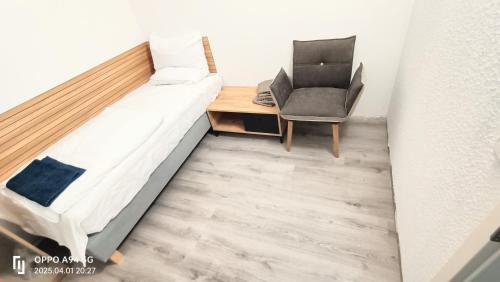a small bedroom with a bed and a chair at Neu-Isenburg in Neu Isenburg