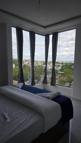a bedroom with a bed and a large window at VRK Comfort in Mysore
