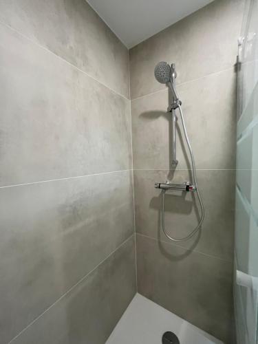 a shower with a shower head in a bathroom at Appartement proche Eurexpo Aéroport Genas Centre in Genas