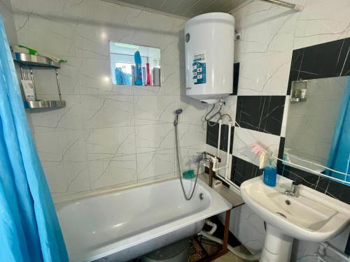 a bathroom with a sink and a tub and a toilet at Ali guest house in Sary-Mogul