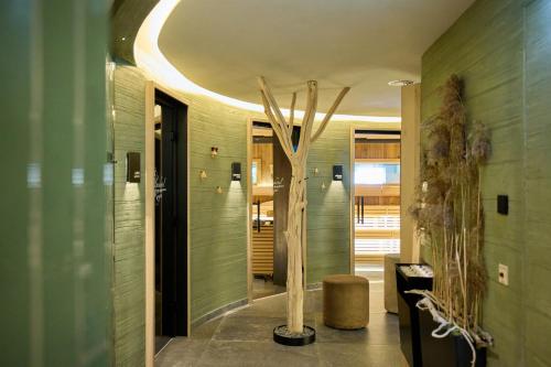 a room with a hallway with a tree in it at Alpenhotel Rieger in Mittenwald
