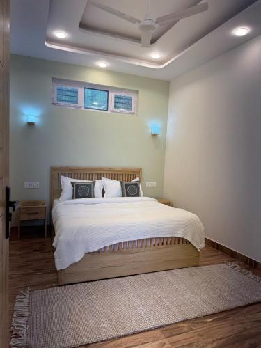 a bedroom with a large bed with white sheets at The Second Home , Chamba Hills in Chamba