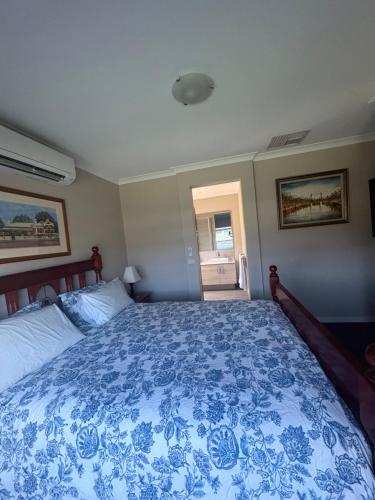 a bedroom with a bed with a blue and white bedspread at Park Views Guest Room in Kilmore