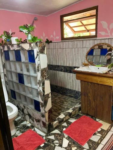 a bathroom with a toilet and a sink at Maupiti Authentique in Te-Fare-Arii
