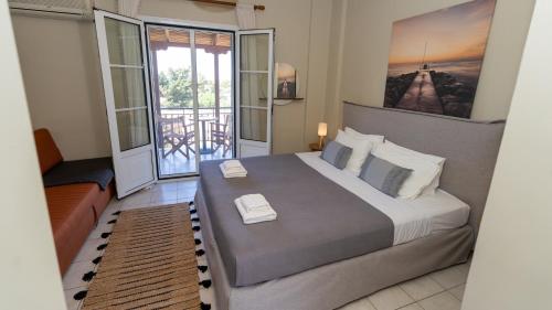 a bedroom with a large bed and a balcony at Fereniki Lemnos Suites in Platy