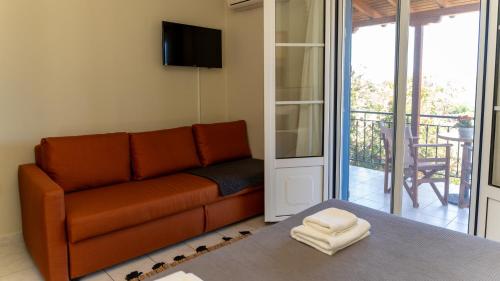 a living room with a couch and a balcony at Fereniki Lemnos Suites in Platy