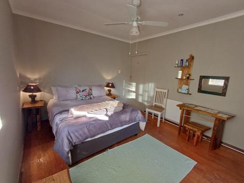 a bedroom with a bed and a table in it at Kliplelie Selfsorg in Tulbagh