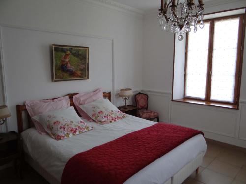 a bedroom with a bed and a chandelier at Domaine de La Bessade in Le Bugue