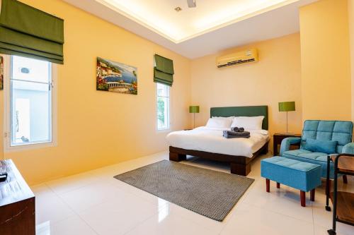 a bedroom with a bed and a blue chair at Private pool villa in Kamala Beach