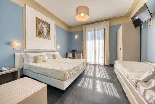 a hotel room with two beds and a window at Hotel Augustus in Rimini