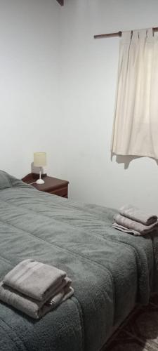 a bedroom with a bed with towels on it at Un rincón en el centro in Merlo