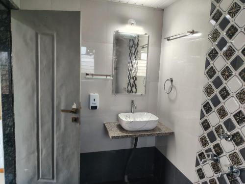 a bathroom with a sink and a mirror at Bliss Paradise Resort in Malvan