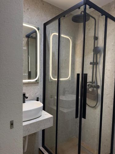 a bathroom with a glass shower and a sink at DD apartments & suites in Paralia Katerinis
