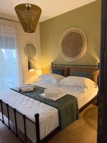 a bedroom with a large bed with two towels on it at DD apartments & suites in Paralia Katerinis