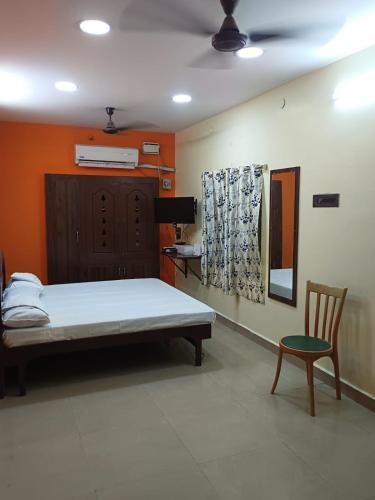 a hospital room with a bed and a chair at Saimithra Riverview Homestay in Tirunelveli