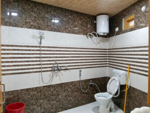 a bathroom with a shower and a toilet at Sherjang Events in Munsyari