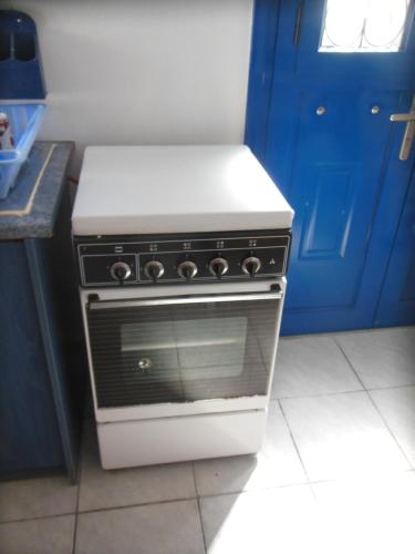 a stove in a kitchen with a blue door at Nagos Home in Nagós