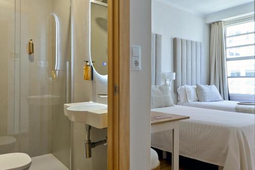 a hotel room with a bed and a sink at Hostal Zahara in Ferrol