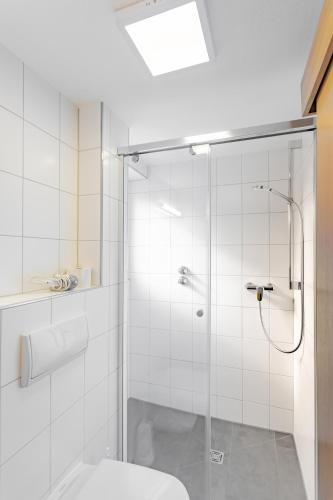 a bathroom with a glass shower with a toilet at Hotel Garni WEISSES LAMM in Erlangen