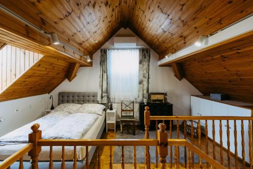 a bedroom with a bed and a wooden ceiling at Ferienwohnungen Proschahaus in Eisenberg an der Pinka