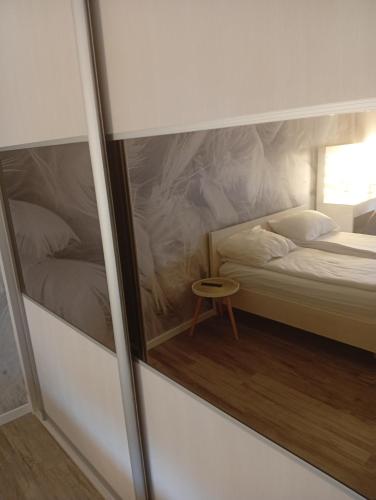 a small bedroom with a bed and a small table at Apartman DALIAROSE Sarajevo in Sarajevo