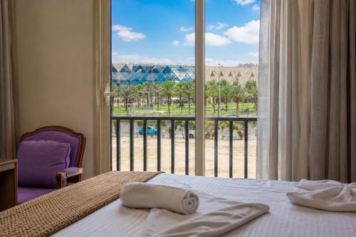 a bedroom with a bed and a large window at Kush Hotel, Grand Museum & Pyramids View in Cairo