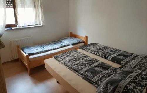 two beds in a small room with a window at Soča Trails Apartment #4 in Srpenica