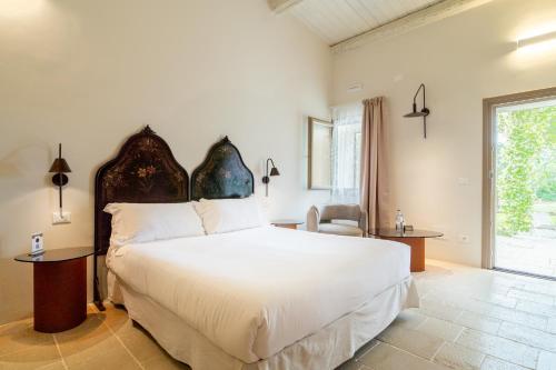 a bedroom with a large white bed and a window at Baglio Siciliamo Country House in Noto Marina