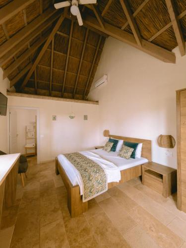 a bedroom with a bed in a room with wooden ceilings at Laguna Vadu in Vadu