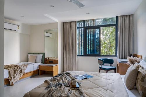a hotel room with two beds and a window at Hotel Serenova, Pune- Pure Veg in Pune