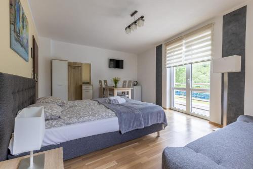 a bedroom with a bed and a large window at Willa Beskidek PLUS in Szczyrk