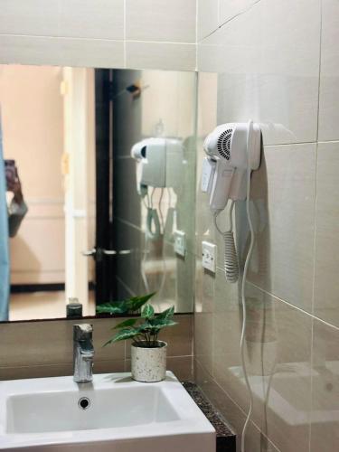 a bathroom with a sink and a hair dryer at Mactan Newtown Condo Rentals in Punta Engaño