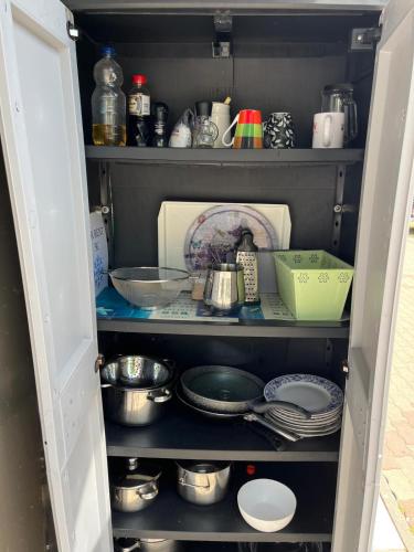 an open pantry with dishes and utensils at Camp Mali Baška in Baška