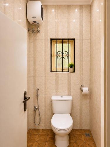 a bathroom with a toilet and a window at IMSMART Luxury Apartment in Uyo