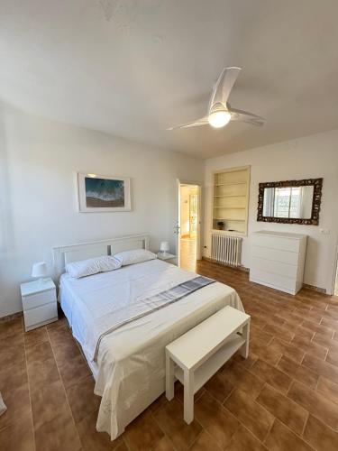 a bedroom with a white bed and a ceiling fan at La casetta sul mare in Ortona