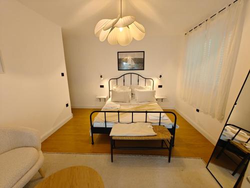 a bedroom with a bed and a couch and a chandelier at Casa Valsecca in Krk