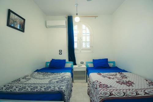 a room with two beds and a window at Luxor Guest House in Luxor