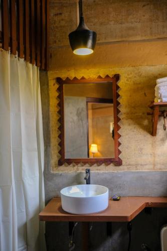a bathroom with a sink and a mirror at Tiger Track Eco Lodge in Bardiyā