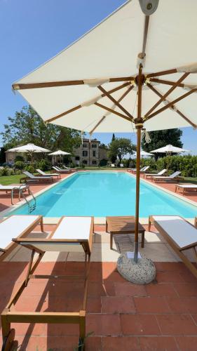 a large swimming pool with a large white umbrella at I Costanti in Caldiero